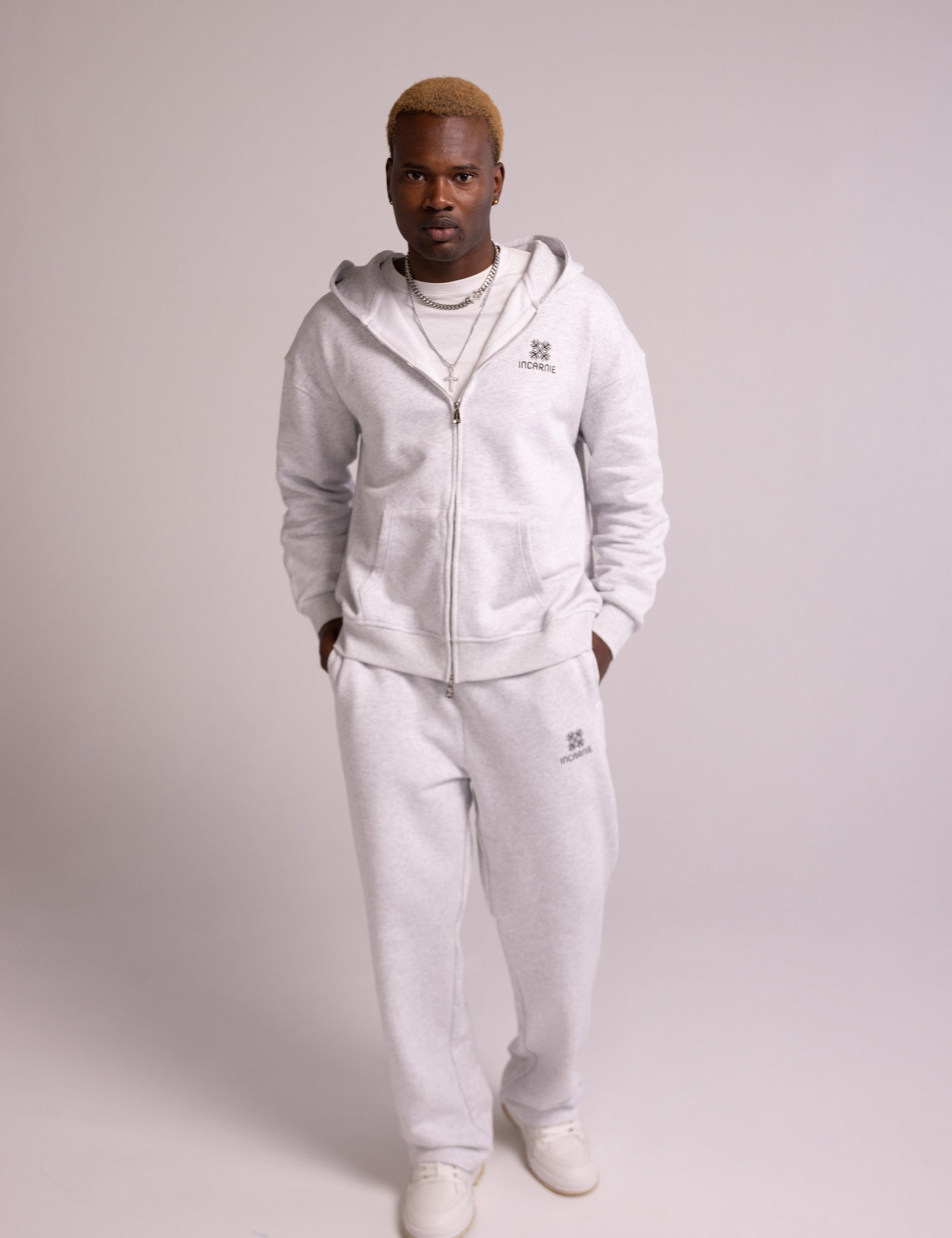 Person wearing a grey tracksuit on a plain background