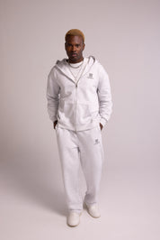 Person wearing a grey tracksuit on a plain background