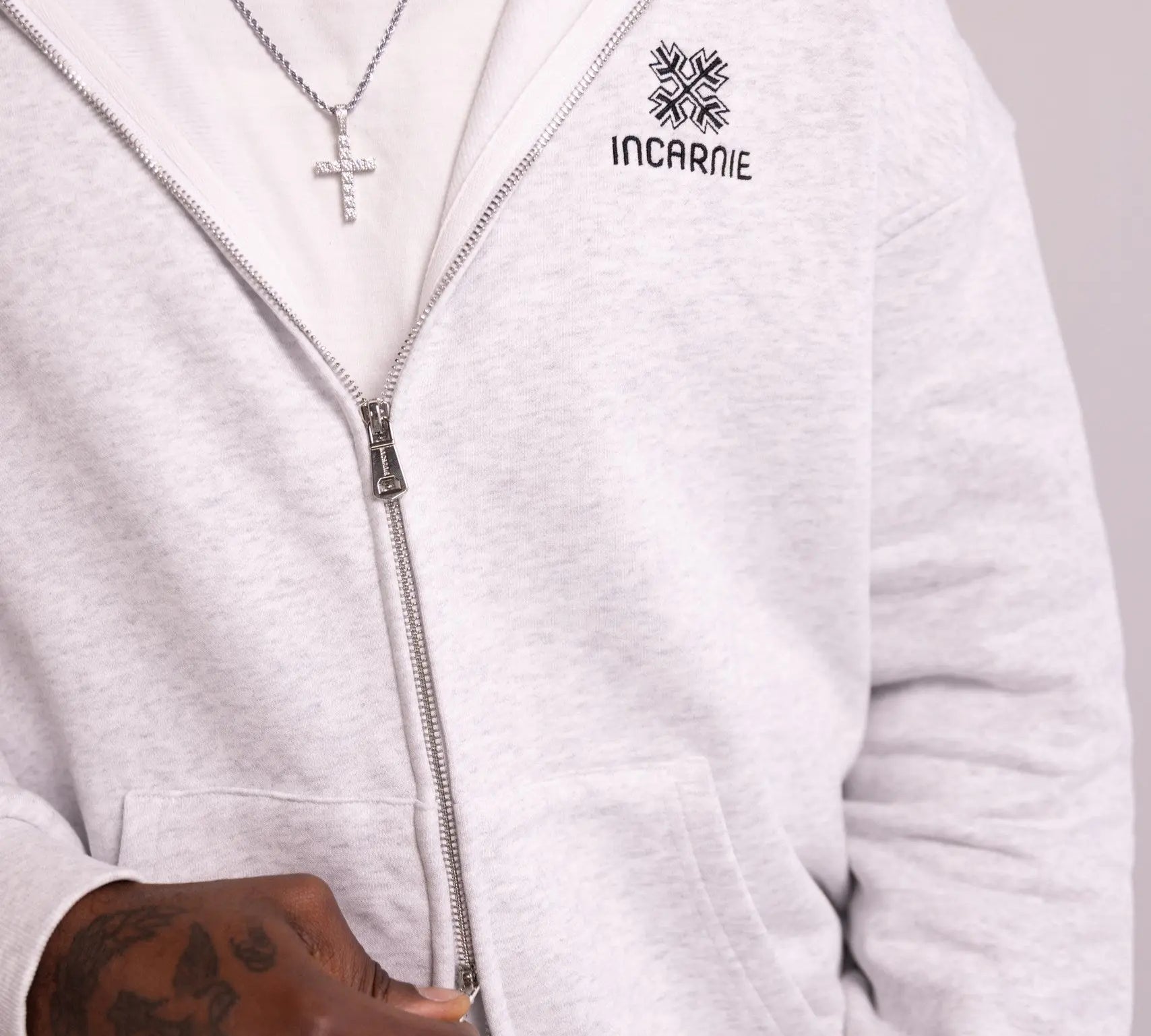 White hoodie with 'INCARNIE' logo worn by a person, on a plain background