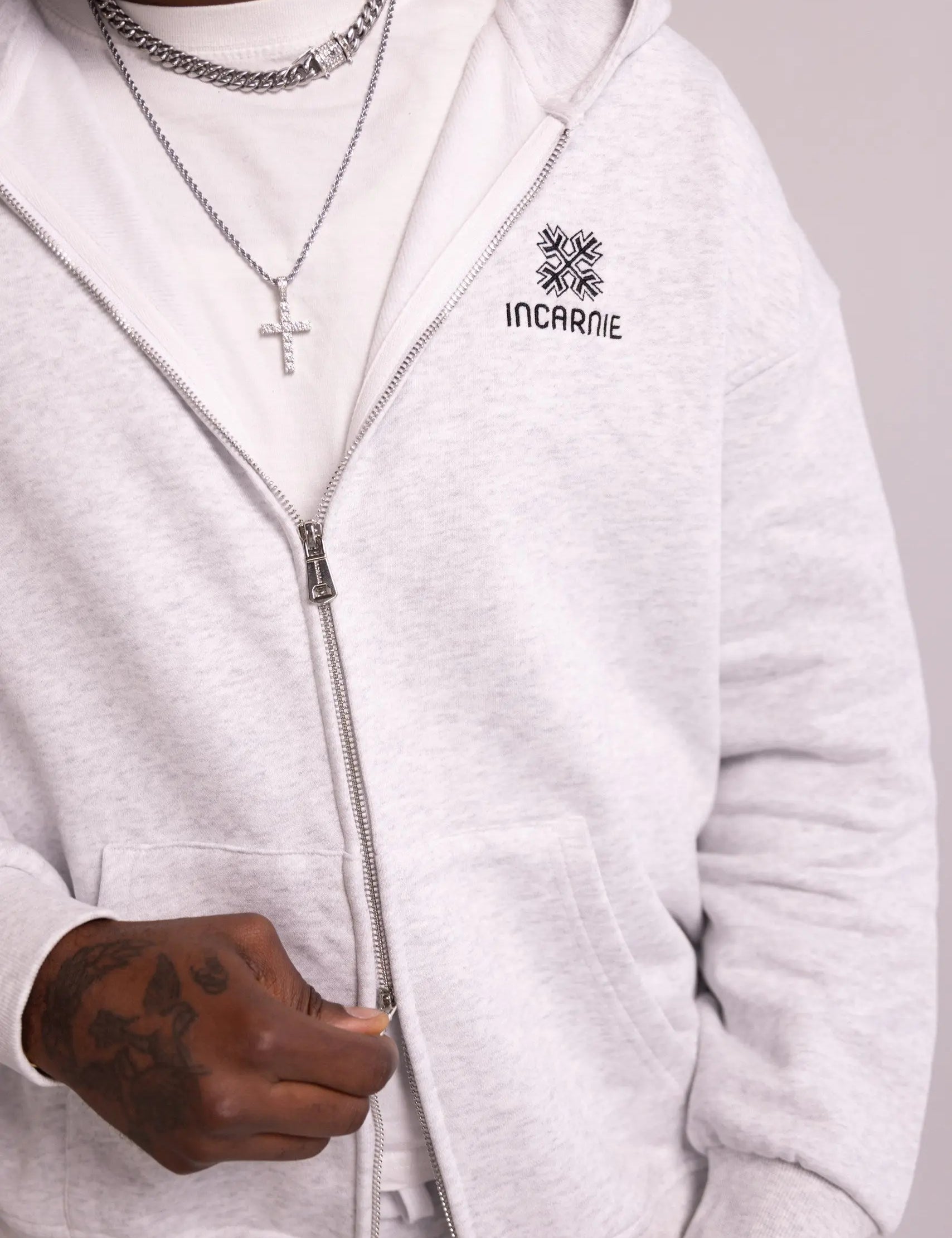 White hoodie with 'INCARNIE' logo worn by a person, on a plain background