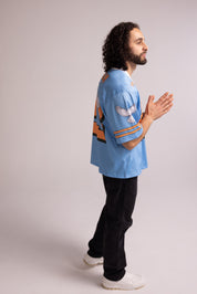 Man wearing a light blue jersey with a colorful design on a plain background