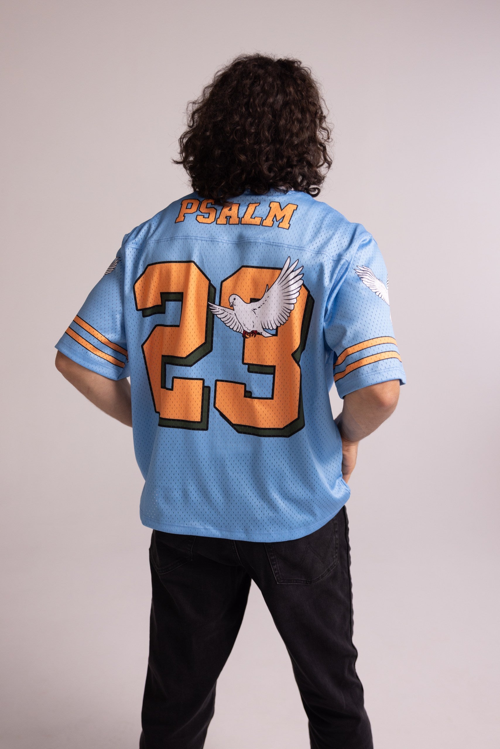Person wearing a blue jersey with 'Psalm 23' printed on the back against a plain background