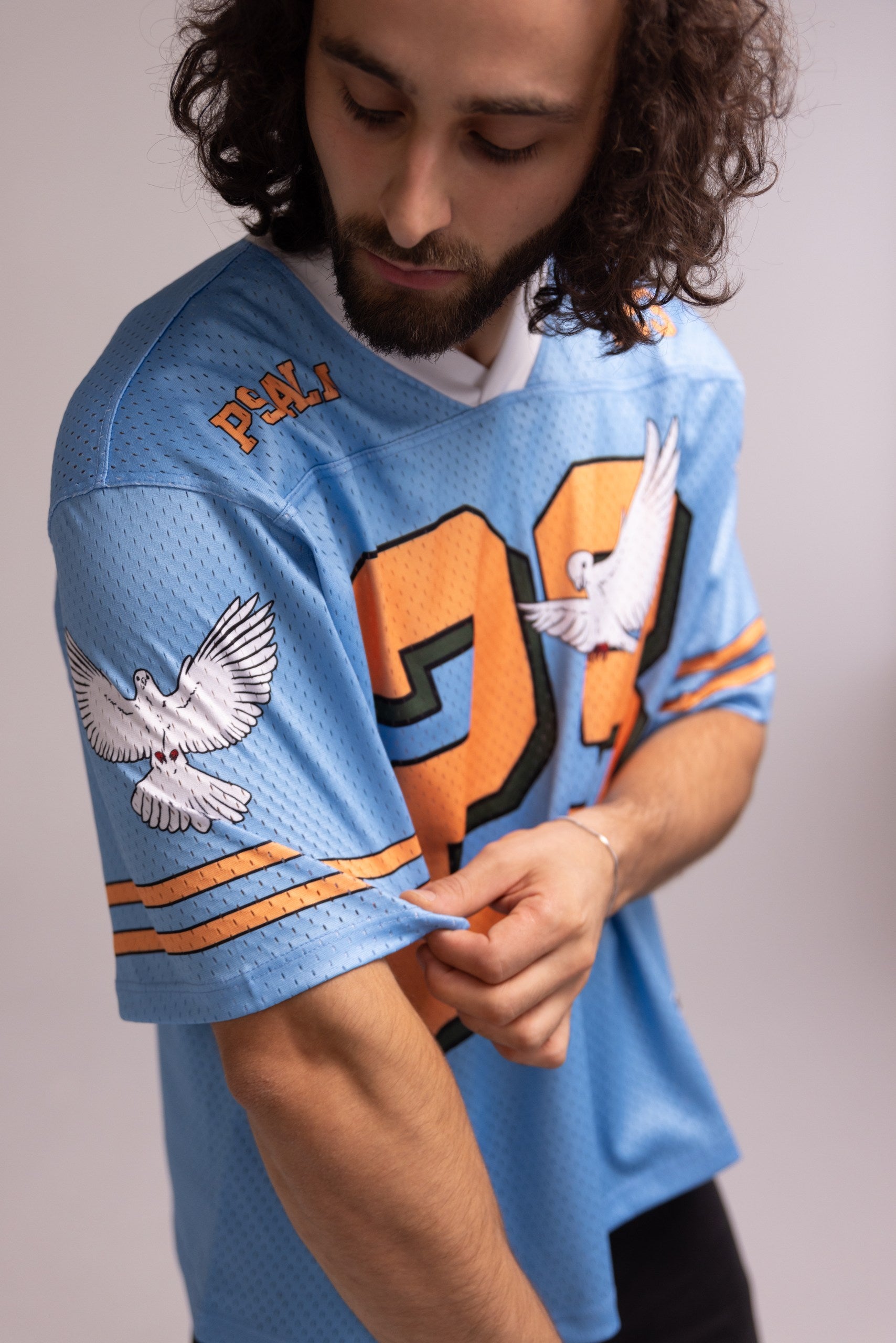 Person wearing a blue sports jersey with orange and white accents