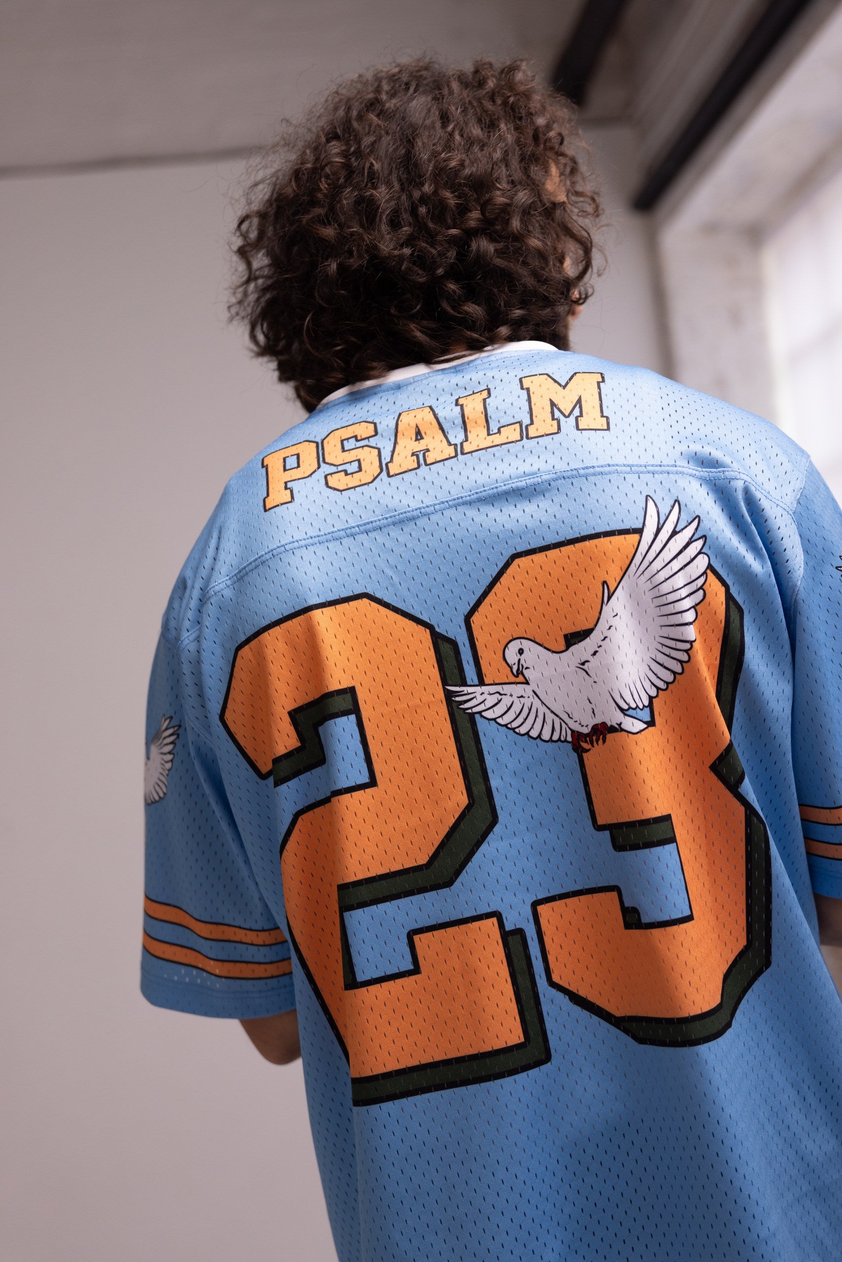 Person wearing a blue sports jersey with 'PSALM' and number '23' on the back.