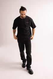 Man wearing a black t-shirt and pants on a white background