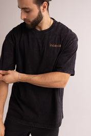Man wearing a black t-shirt with 'incarnie' logo on a plain background