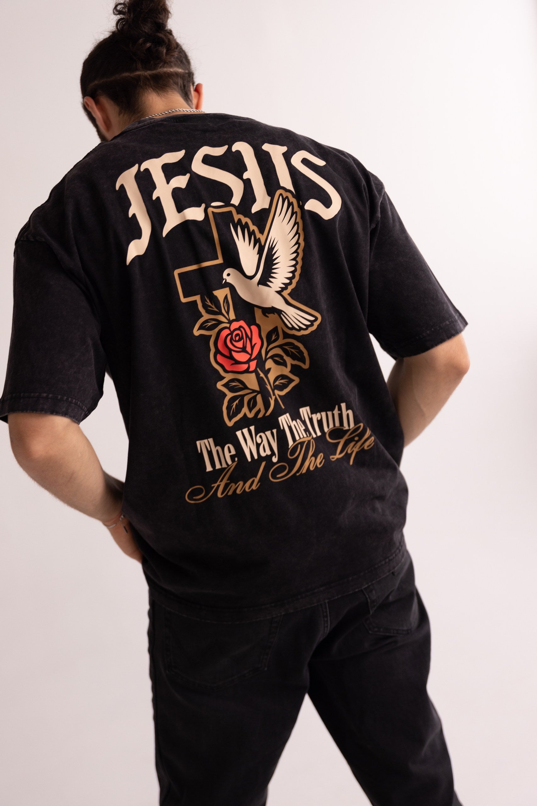 Person wearing a black t-shirt with religious text and symbols on the back.