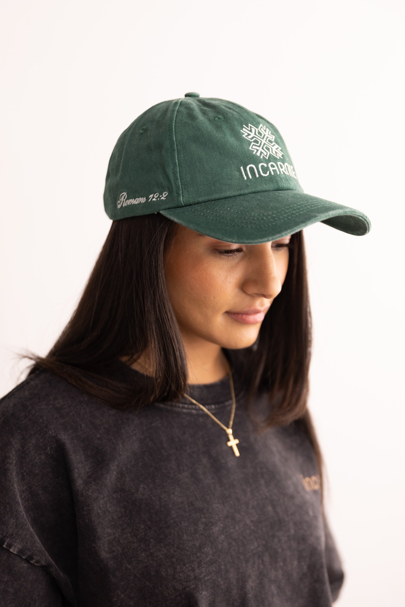 Person wearing a green cap with text on a white background