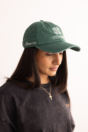 Person wearing a green cap with text on a white background