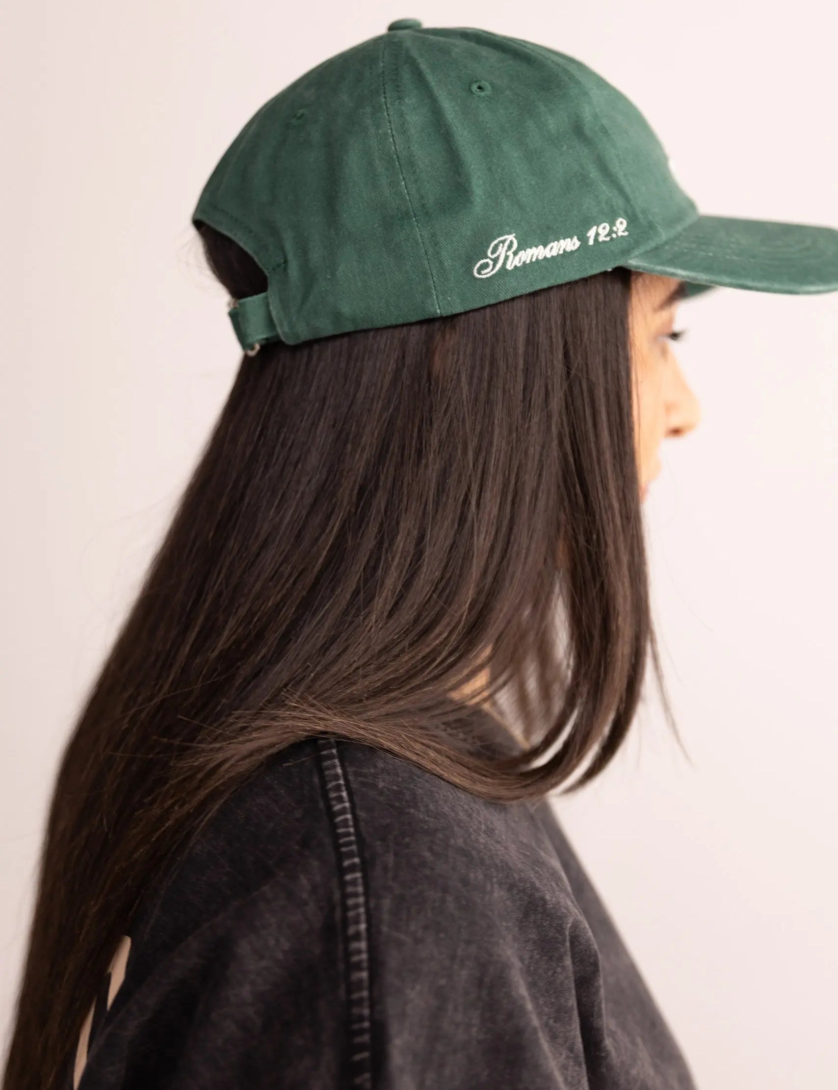 Person wearing a green cap with text on a plain background