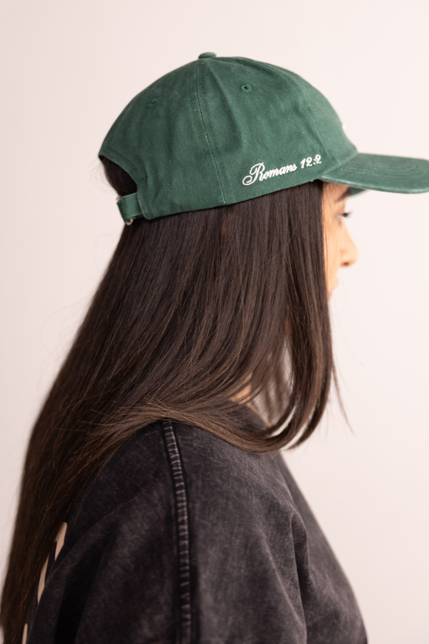 Person wearing a green cap with text on a plain background