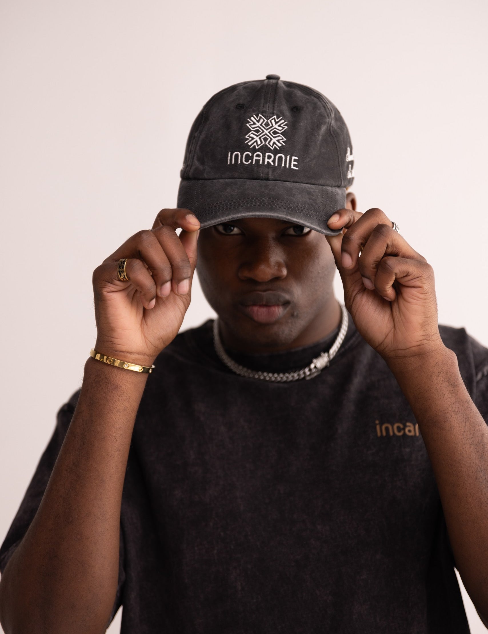 Person wearing a black cap with 'INCARNIE' branding on a plain background