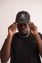 Person wearing a black cap with 'INCARNIE' branding on a plain background