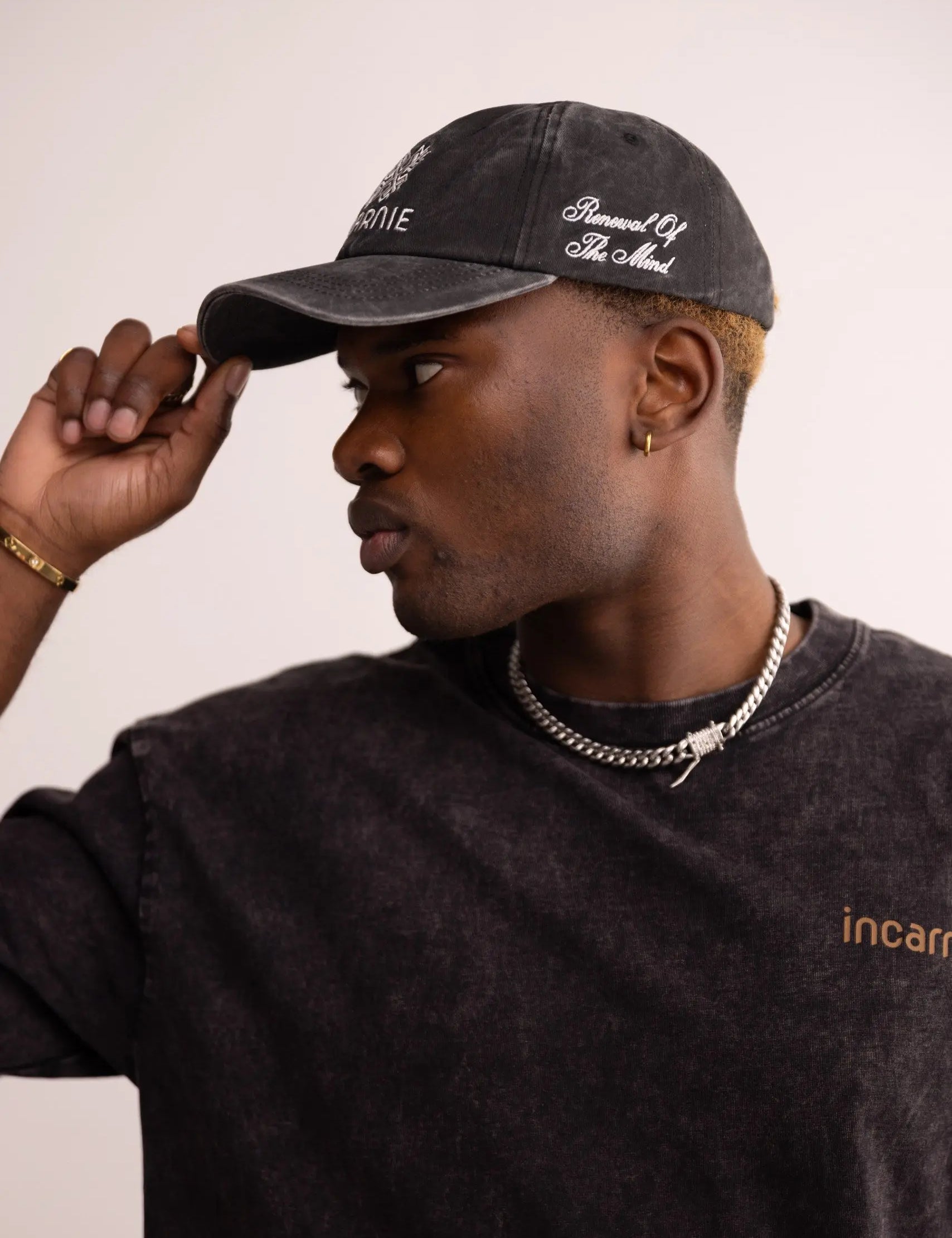 Man wearing a black cap and black shirt with 'incarnie' branding.