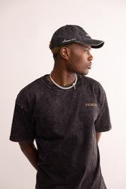 Person wearing a black cap and t-shirt with 'incarnate' branding on a plain background