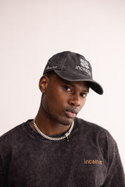 Man wearing a black cap and sweatshirt with 'incarnie' branding on a light background