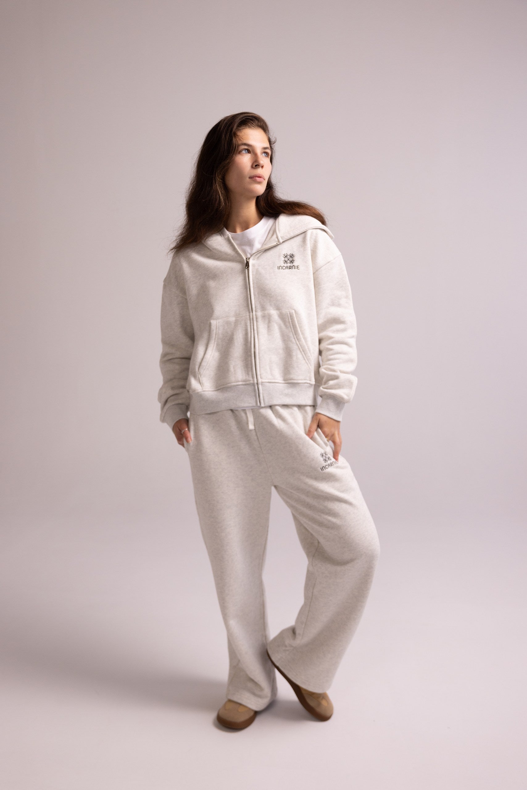 Woman wearing a white tracksuit on a plain background
