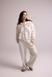 Woman wearing a white tracksuit on a plain background