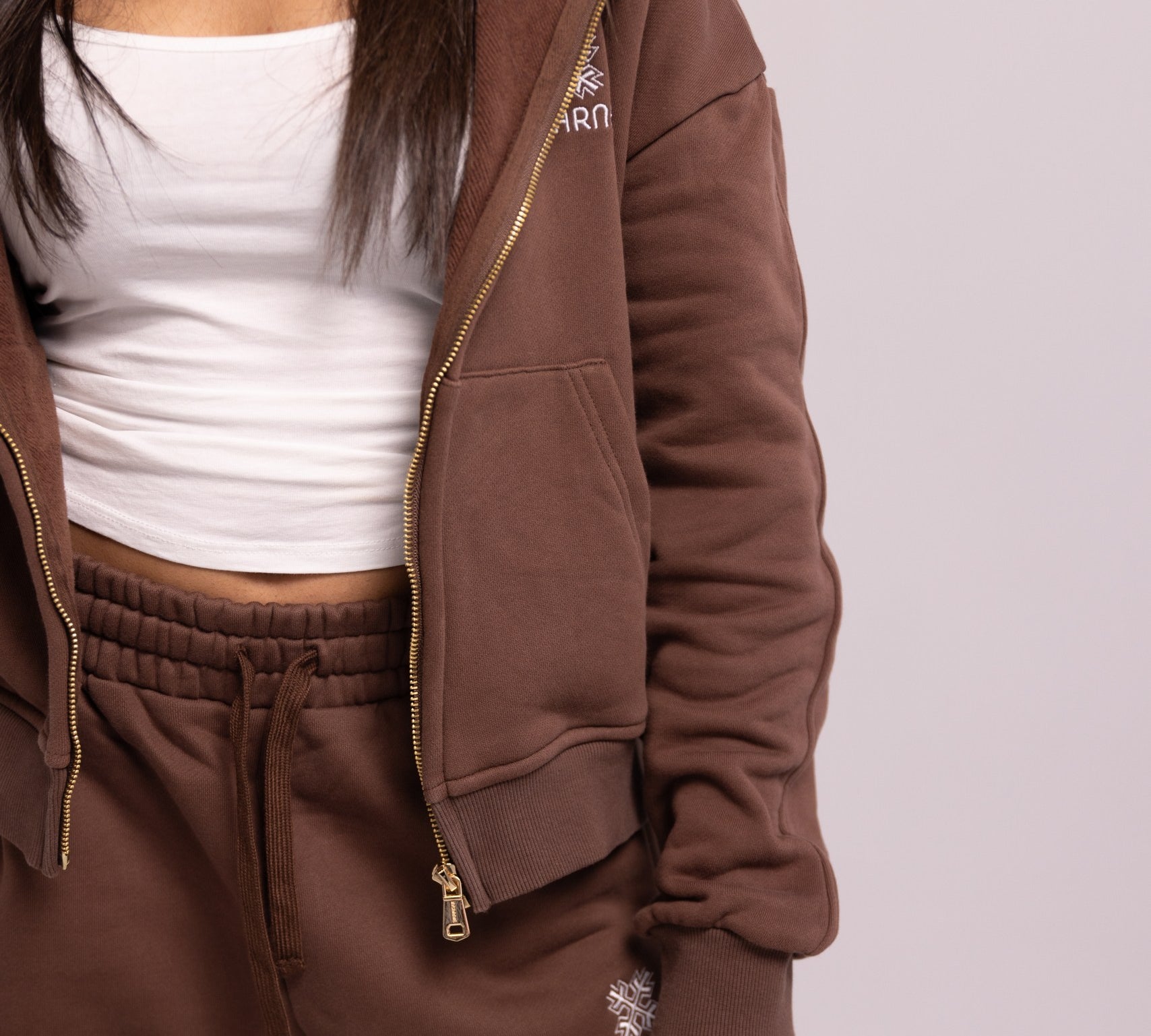 Brown tracksuit with white top on a plain background