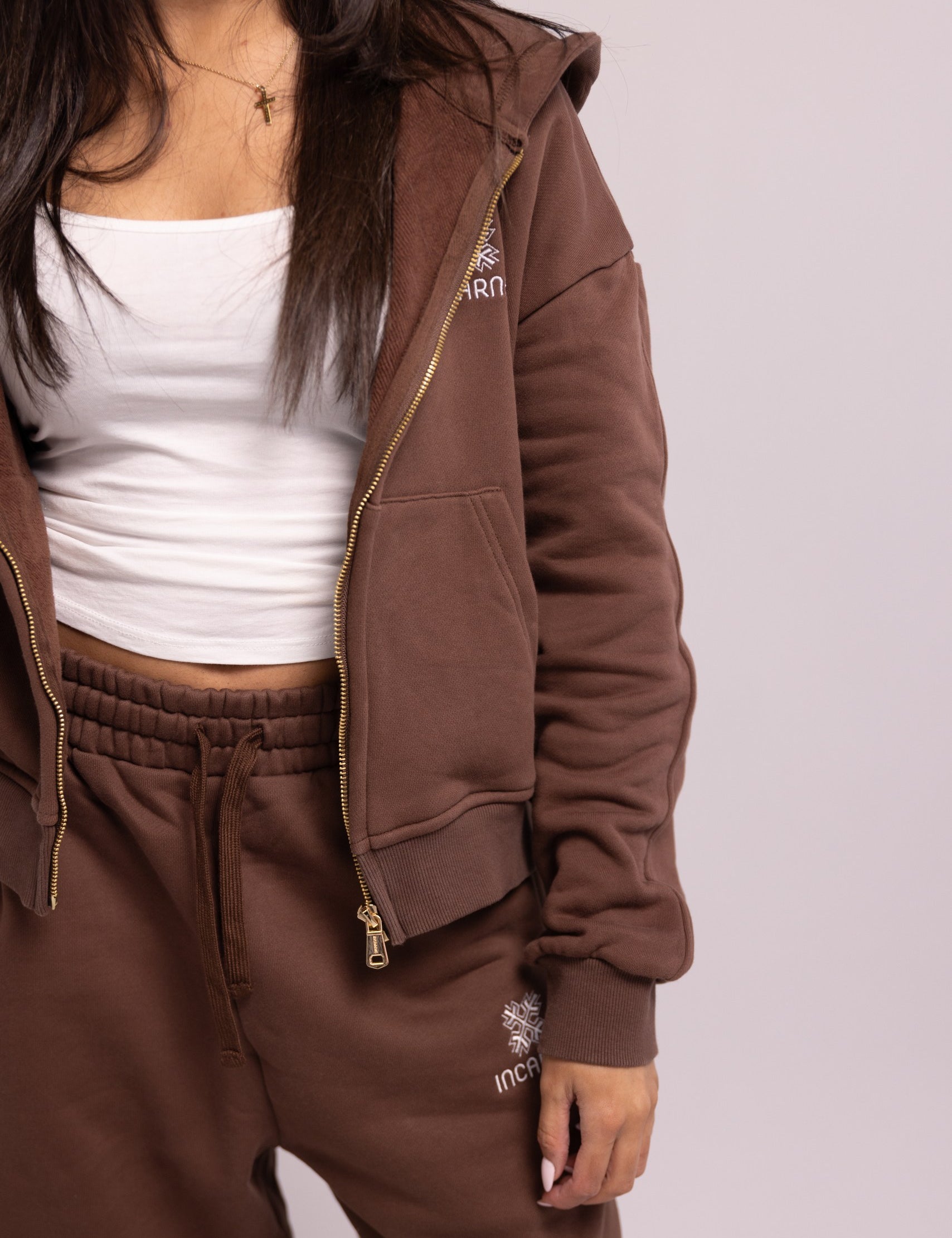 Brown tracksuit with white top on a plain background