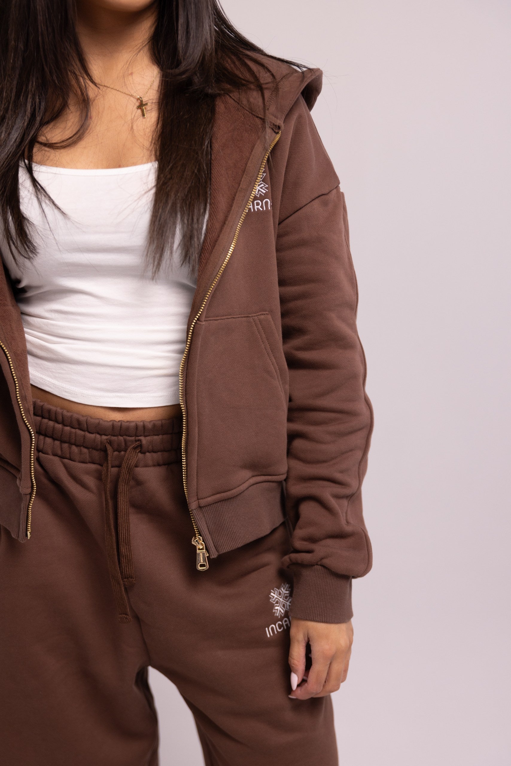 Brown tracksuit with white top on a plain background