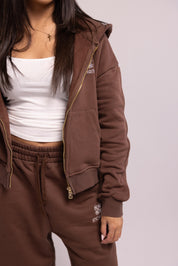 Brown tracksuit with white top on a plain background