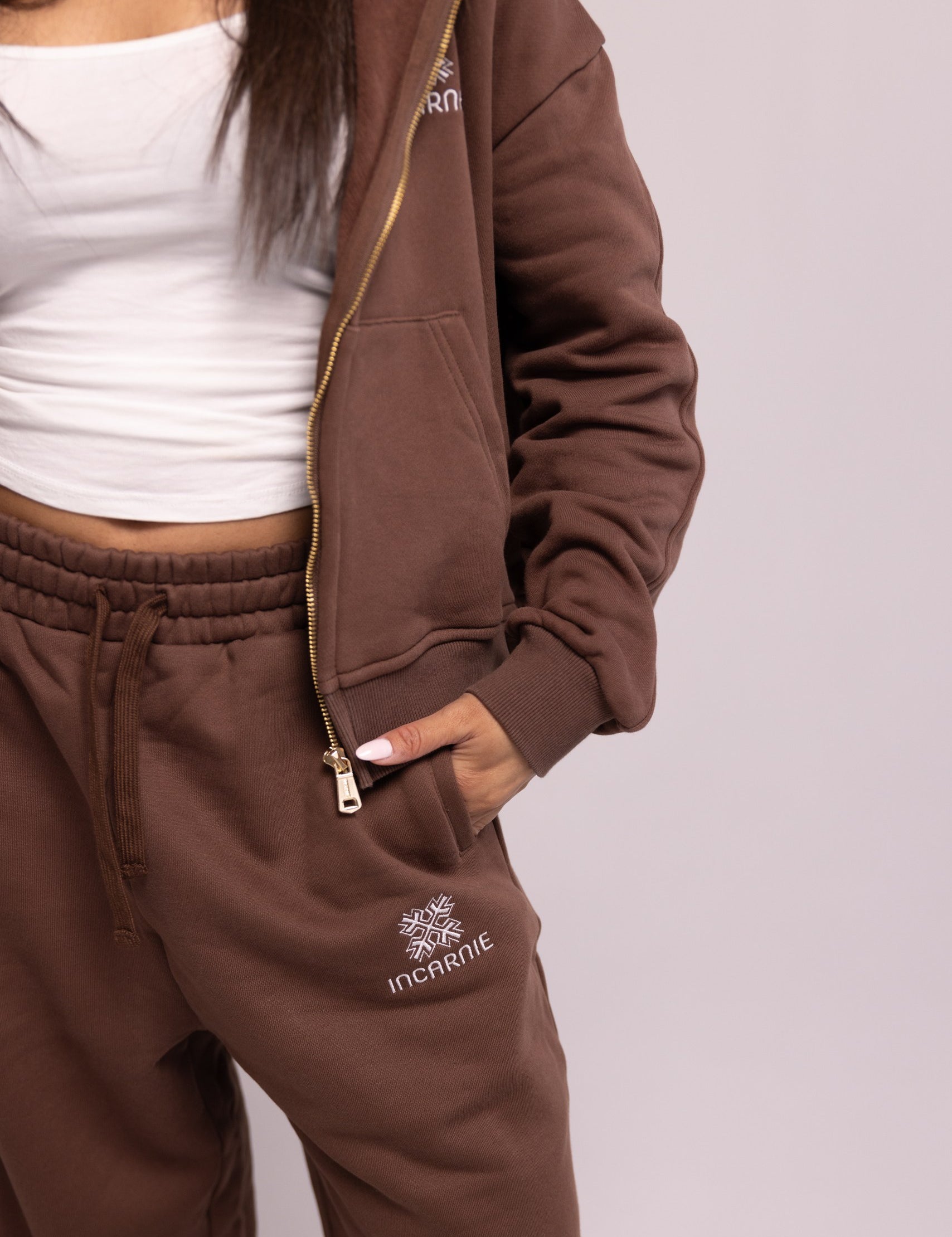 Brown tracksuit with brand logo on a plain background