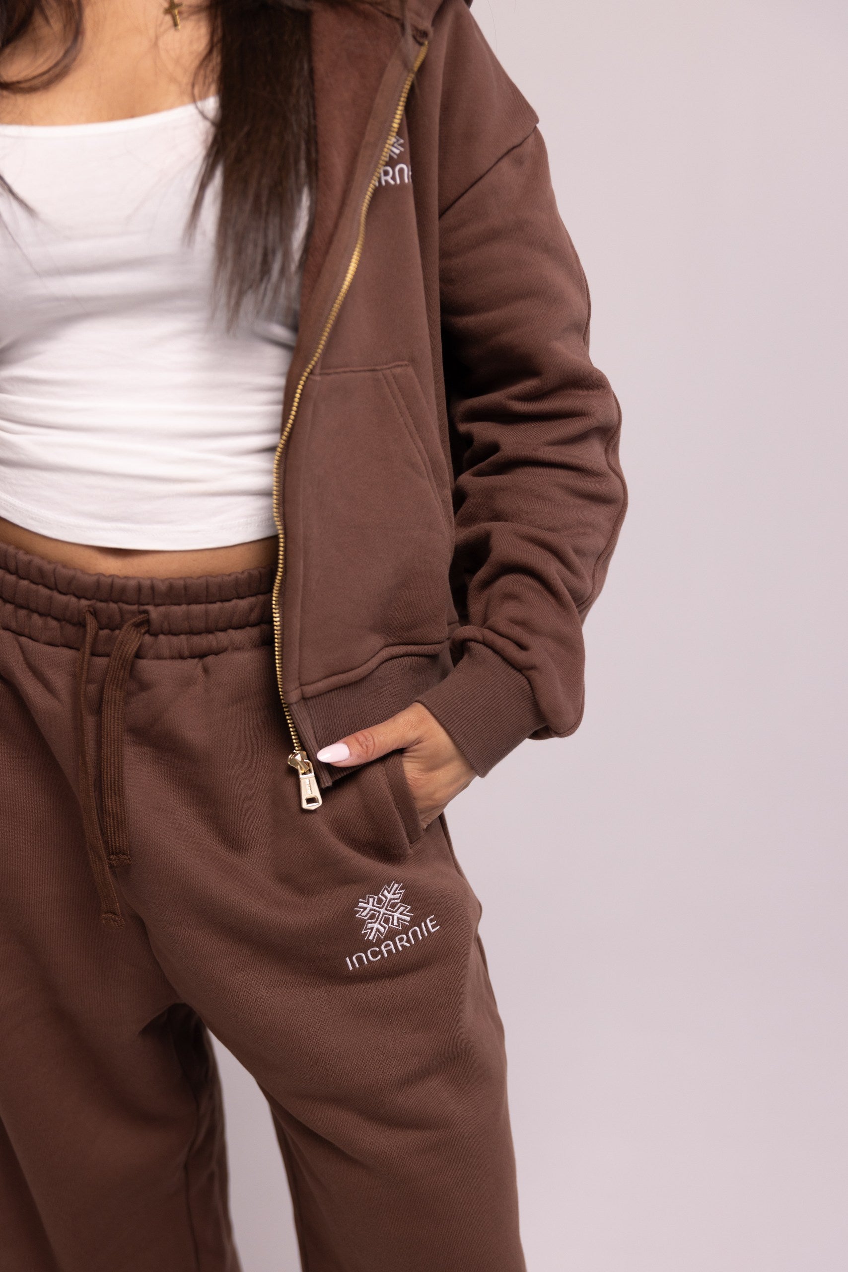 Brown tracksuit with brand logo on a plain background