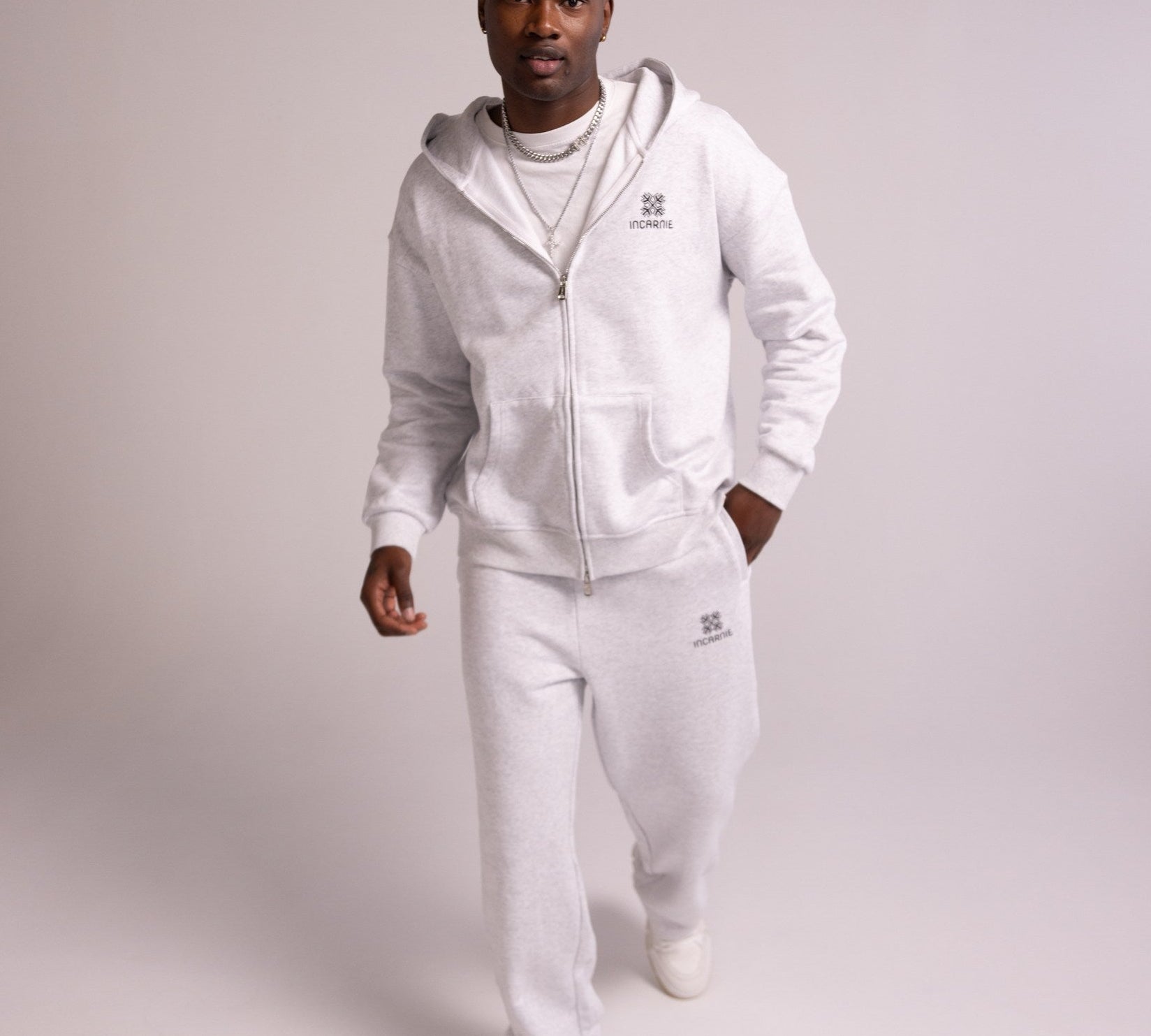 Person wearing a grey tracksuit on a plain background