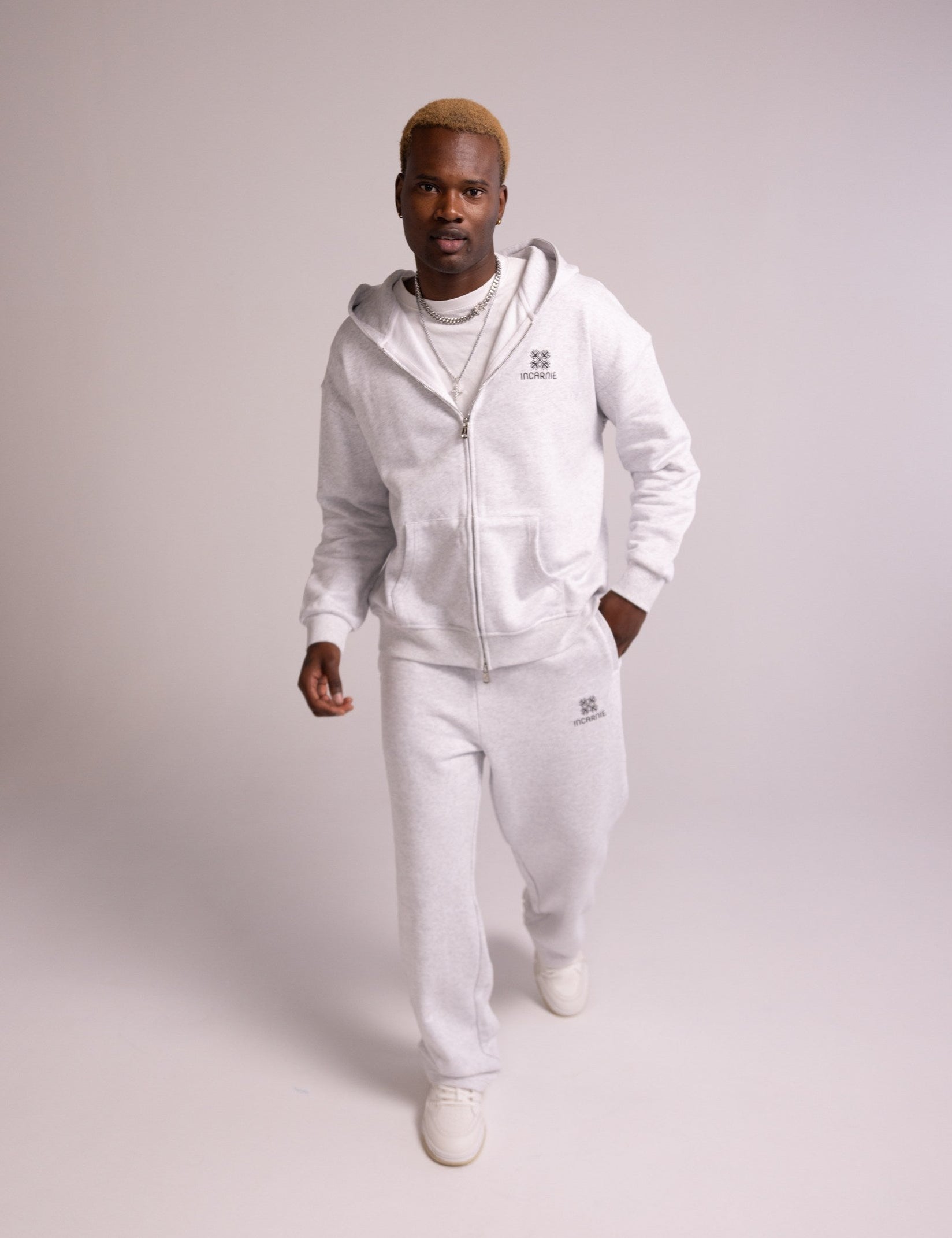Person wearing a grey tracksuit on a plain background
