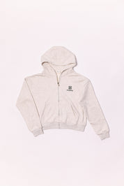 Beige hoodie with a brand logo on a light pink background