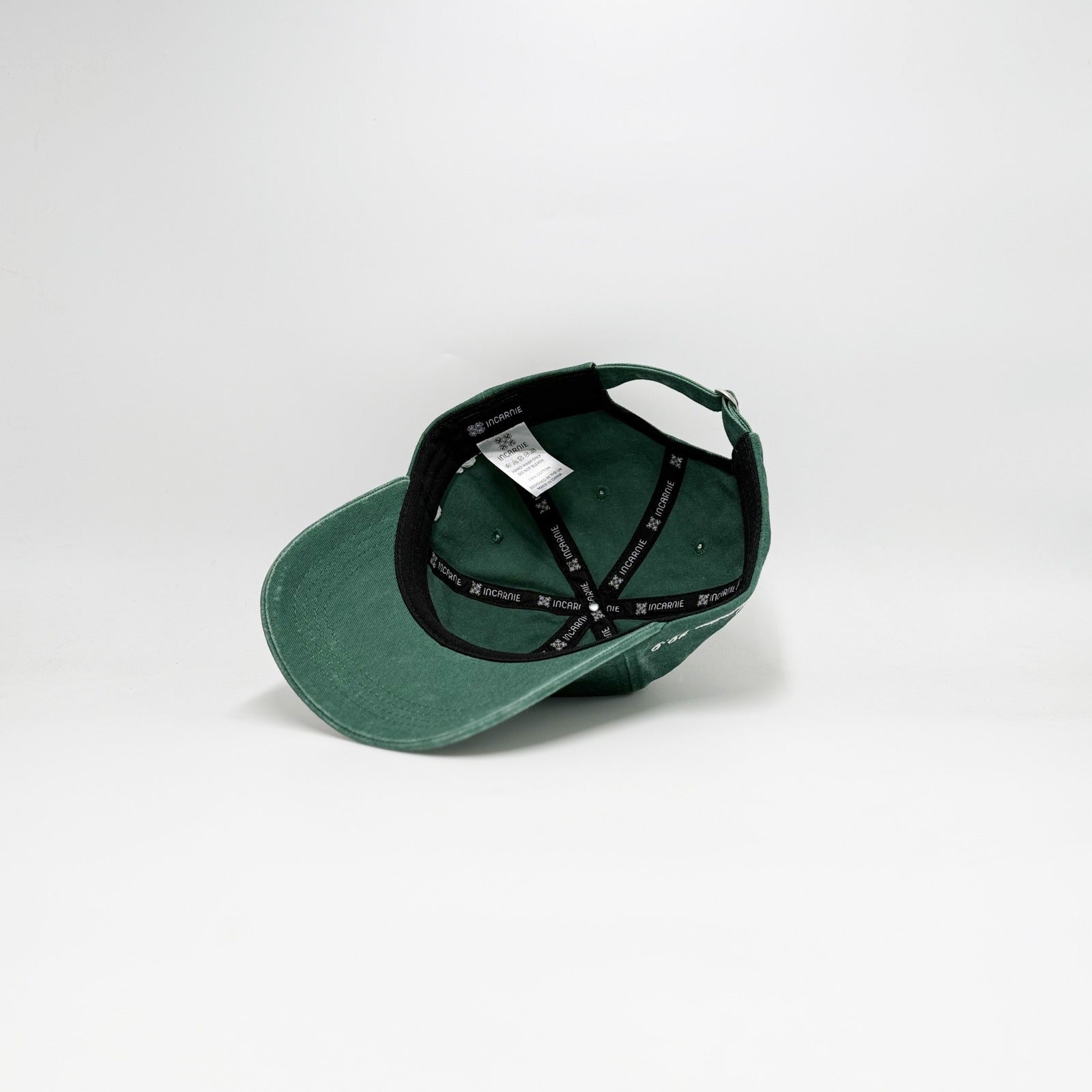 Green cap with black strap on a white background